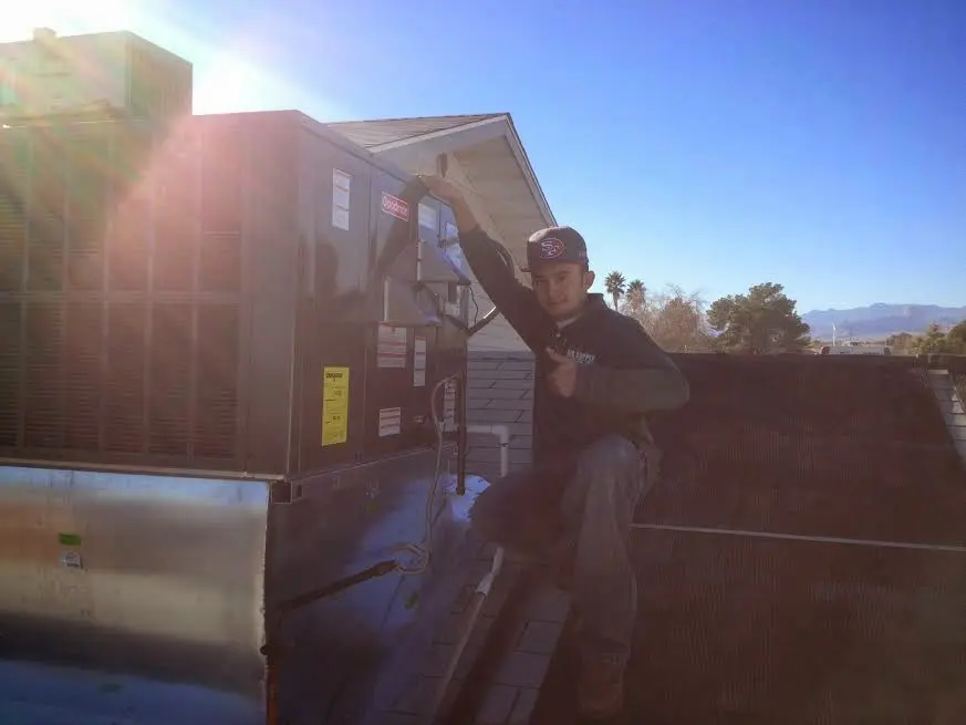 HVAC technician performing AC Tune-Up on a rooftop unit in Silverton